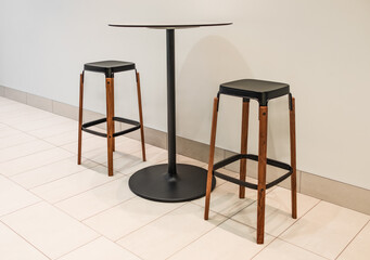 Bar chairs and round cafe table. Round coffee table with steel base and two tall wooden bar stools. Tall table steel leg