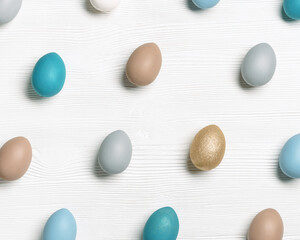 Easter eggs pastel colored as pattern on wooden background. Minimal Easter celebration concept, dyed chicken egg with color gradient from blue to beige coloured. Top view table, geometric layout