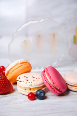 Macaron pink, orange and beige, blue on marble style. A beautiful and beautiful French dessert. Fruits and epoxy resin and flowers on the background..