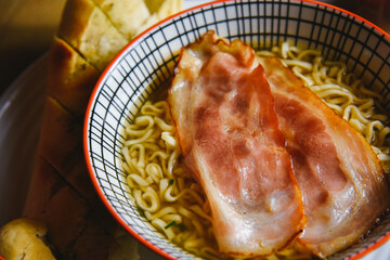 Instant pasta, Japanese and Chinese noodles. Ramen type soup in a plate with chopsticks, junk fast food. Quick-cooking pasta with bacon.