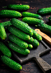 Fresh cucumbers on a wooden cutting board. 