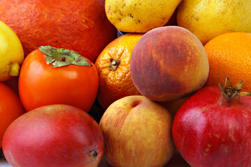 Group of fruits in yellow, red and orange shades close-up. Fresh fruits.