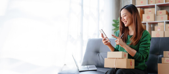 Portrait of Starting small businesses SME owners female entrepreneurs working on receipt box and check online orders to prepare to pack the boxes, sell to customers, SME business ideas online.