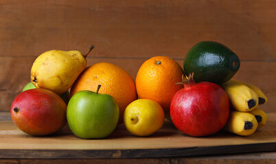 Group of fruits of yellow, red and green shades on a wooden table. Fresh fruits.