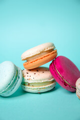 Colorful macarons. Small French cakes. Sweet and colorful french macarons on a blue background. Gift for Valentine's Day.