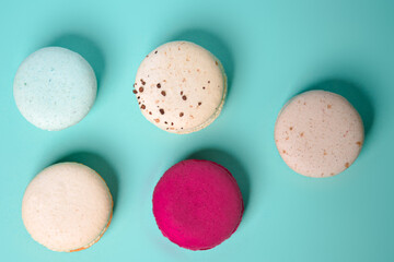 Colorful macarons. Small French cakes. Sweet and colorful french macarons on a blue background. Gift for Valentine's Day.
