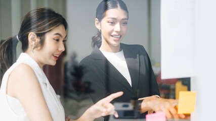 Southeast asian business women wearing suit with smile face talking together in office