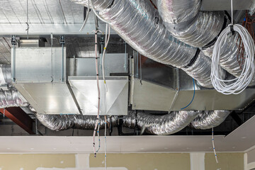 construction site showing the interior of a roof with installation of air conditioning ducts