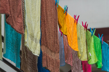 Close-up on a rope, freshly washed colorful  towels  other things are hung