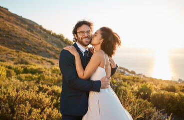 Married couple, kiss and cheek and smile in nature for honeymoon, travel or sunset adventure...
