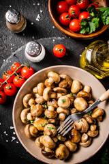 Fried mushrooms in a bowl with cherry tomatoes. 