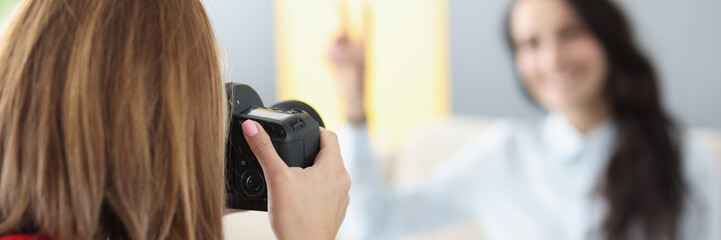 Woman photographer photographs model on camera at home