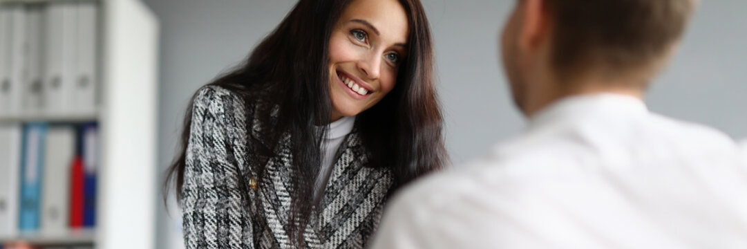 Beautiful smiling secretary flirting with boss at workplace