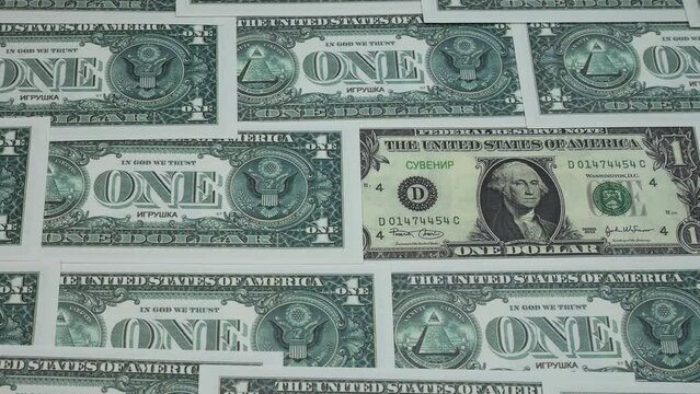American one-dollar bills are spread out on the table. A lot of money fills the simple people in the picture.