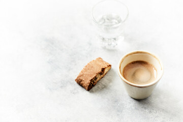 Cup of coffee with cantuccini (Italian biscuit) on bright stone background. Copy space. 