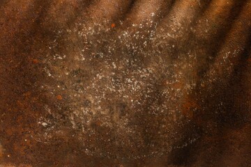 Fototapeta premium Rusty metal plate- corrosion on a dark red background. Abstract rust texture