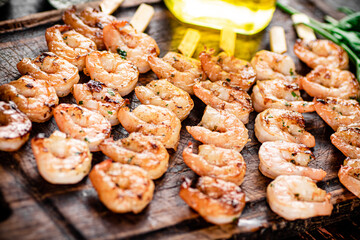 Grilled shrimp on a wooden cutting board.