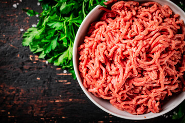 Minced fresh meat in a bowl with parsley. 