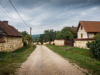 Fototapeta na wymiar country houses in the village. dirt road crossing a village with stone houses. Chidea village from Cluj