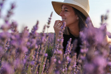 beautiful smiling woman gazing at the lavender fields at sunset