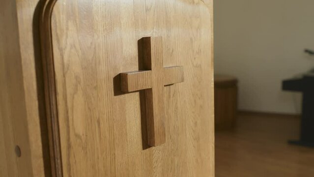 No people shot of wooden lectern decorated with minimalistic cross in modern Catholic church