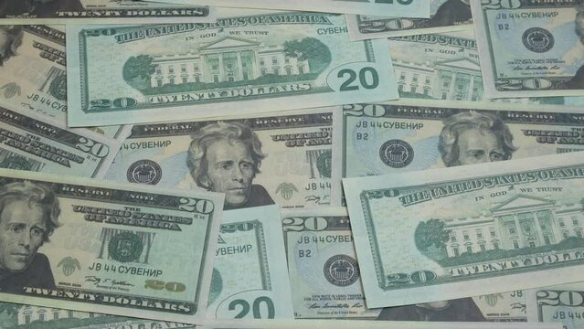 Twenty dollar American bills are spread out on the table. A lot of money fills the simple people in the picture.