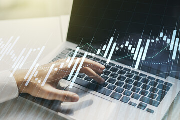 Double exposure of abstract creative financial diagram with hand typing on computer keyboard on background, banking and accounting concept
