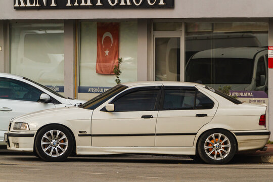 Side, Turkey -January 21, 2023:    white  BMW 3-series  is parked  on the street in city against the backdrop of a shops