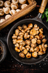 Fried small mushrooms in a frying pan. 
