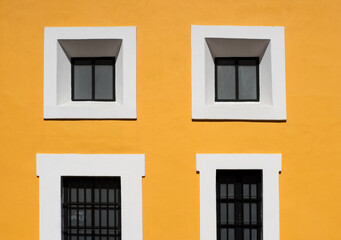 Fototapeta na wymiar white windows on the yellow wall