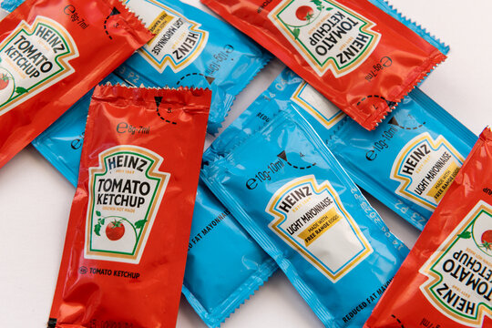 London. UK- 01.22.2023. Small packaged portions of Heinz tomato ketchup and mayonnaise isolated in white
