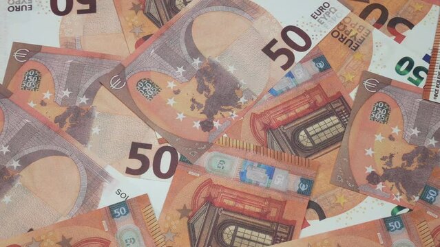There are fifty euros on the table. A lot of money fills the common people in the picture. European currency with a denomination of 50 euros.