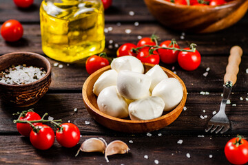 Mozzarella cheese on a plate on a table with tomatoes and spices. 