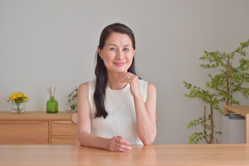 リビングでくつろぐ笑顔の60代女性