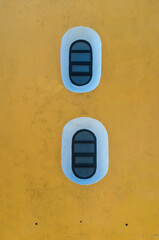 oval window on a yellow wall