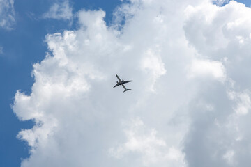 Fototapeta na wymiar 파란하늘과 구름이 가득한 하늘을 비행하는 비행기