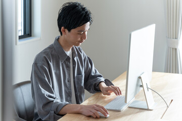 パソコンで仕事する若い男性