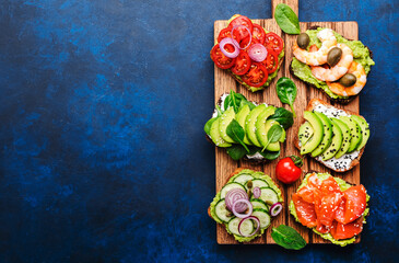 Avocado sandwiches or toast set: with salmon, shrimps, tomatoes, cucumbers, soft cheese and...