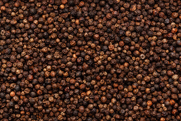 Black pepper, peppercorns, dry spice, food background texture, top view