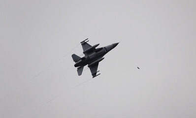 f-16 jet fighter with cloudy sky and falcon silhouette in the background