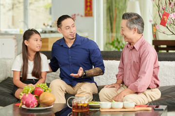 Teenge girl, father and grandfather spending Chinese New Year together