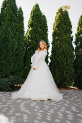 Obraz na płótnie Canvas beautiful bride posing in a white delicate dress in the park.