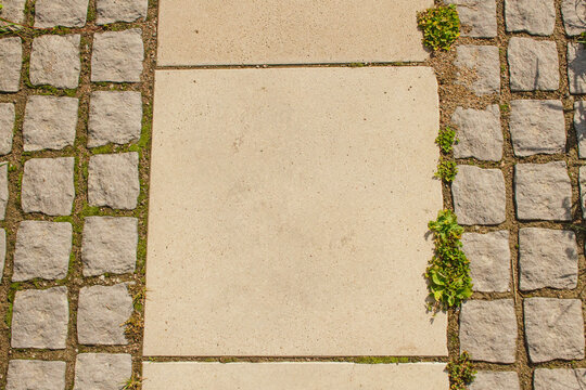 Granite tiles in gray color close-up. The road paved with paving slabs of large and small sizes.