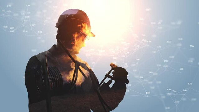 Footage computer graphics and video double exposure. The silhouette of a man in a protective helmet and with equipment is flooded with fire and pipes on a white background with digital graphics