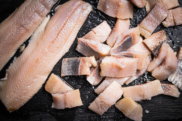 Delicious pieces of salted herring on a stone board. 