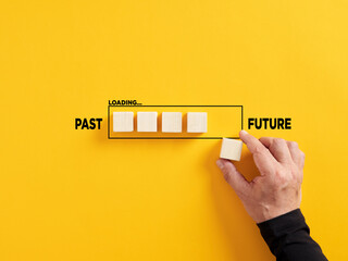 Transition of time from past to future concept. Hand places a wooden cube to the loading bar with...