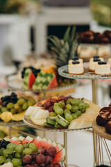 Dessert table for a party. Ombre cake, cupcakes, sweetness and flowers