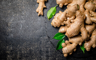 Fresh ginger with leaves on a stone board.  - 564184952