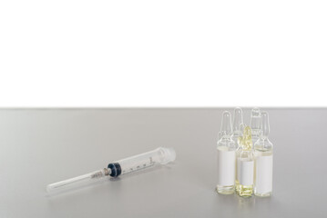 syringe and ampoules on gray table with copy space background