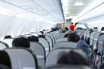 seats in the airplane and passenger sitting all area waiting for the plane taking off from runway.